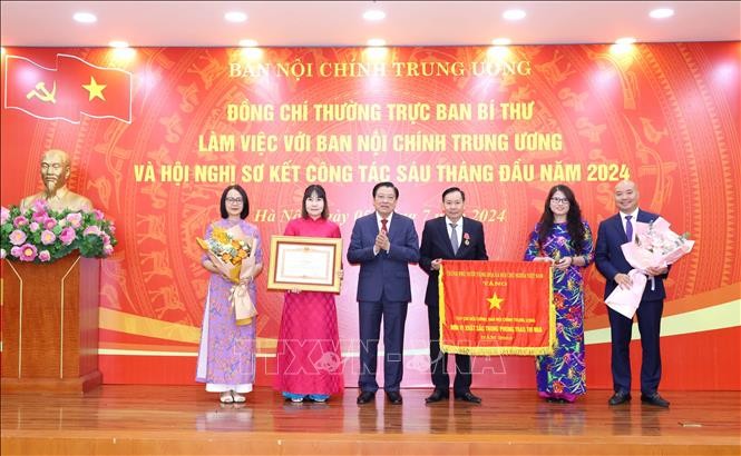 Đồng chí Phan Đình Trạc, Uỷ viên Bộ Chính trị, Bí thư Trung ương Đảng, Trưởng Ban Nội chính Trung ương trao Bằng khen của Thủ tướng Chính phủ cho Bà Nguyễn Thị Thu Huyền và Cờ thi đua của Chính phủ cho Tạp chí Nội chính. Ảnh: Phương Hoa/TTXVN